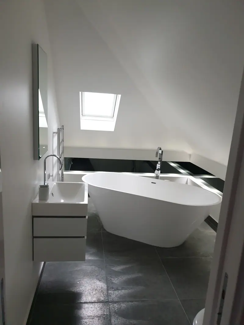 Bathroom renovation with freestanding bath beneath a skylight